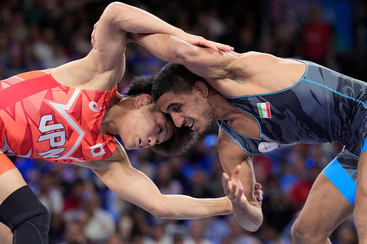 Japan's Kotaro Kiyooka, left, and Iran's Rahman Amouzadkhalili compete in the men’s 65kg freestyle wrestling final on August 11. 