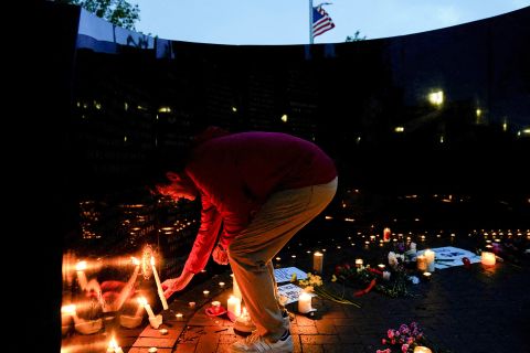 A community member lights a candle at a memorial site for victims of the Highland Park shooting in Illinois on July 5. 