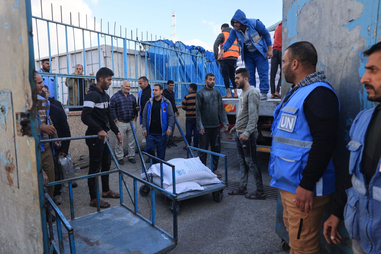 Palestinians receive bags of flour at the United Nations Relief and Works Agency for Palestine Refugees (UNRWA) distribution center in the Rafah refugee camp in southern Gaza on November 21.