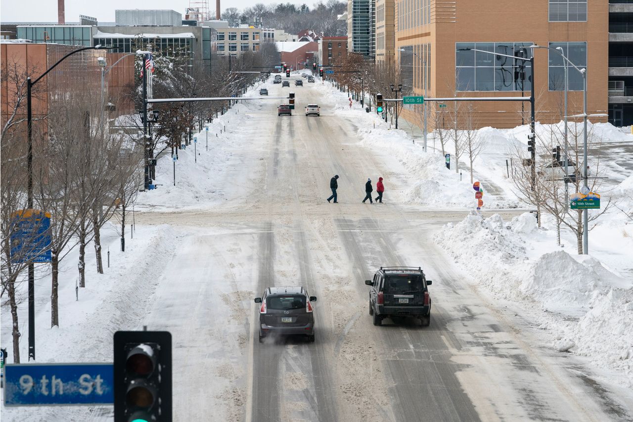 Pedestrians walk through the snow during a winter storm on the day of the Iowa caucuses in Des Moines, Iowa, on Monday.