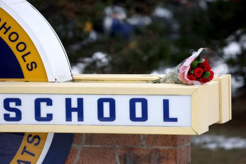 Flowers sit on a sign outside Oxford High School on December 1, a day after a deadly shooting at the school in Oxford, Michigan. 
