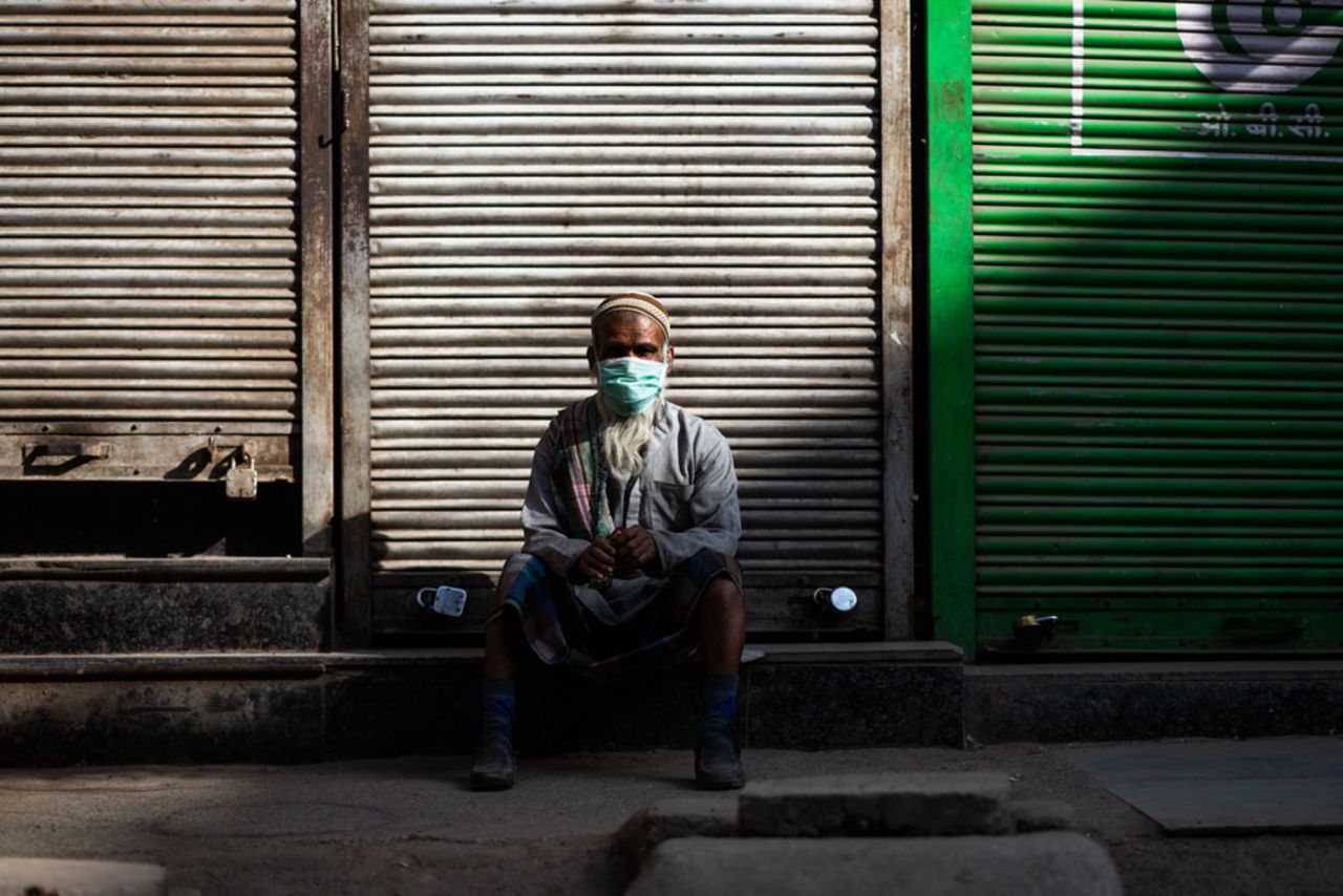 A man wearing a face mask sits in front of a closed shop during a government-imposed nationwide lockdown as a preventive measure against the coronavirus in New Delhi on April 6.