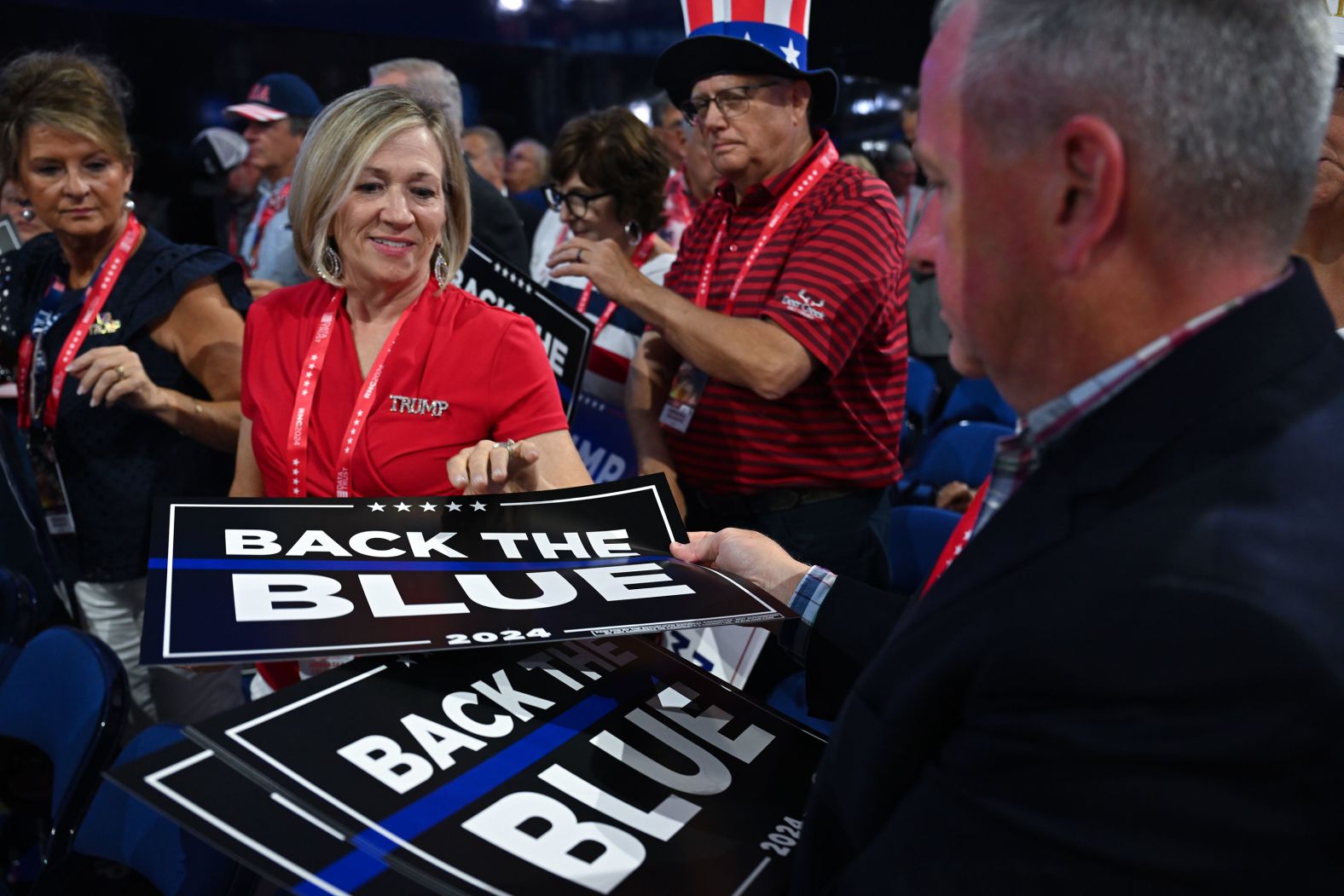 People pass out posters that say “back the blue” on Tuesday.