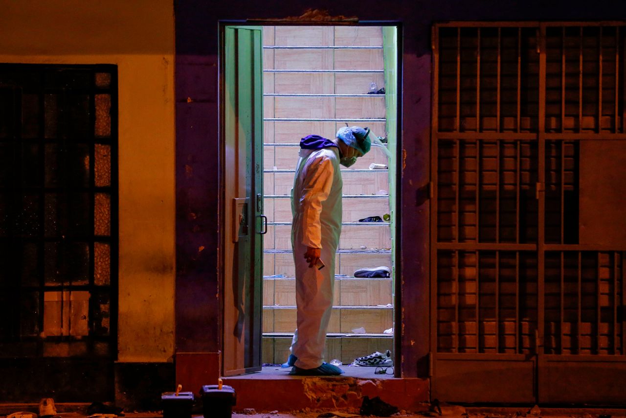 A police investigator stands at the site, on August 23, where 13 people were killed during a raid on a nightclub in Lima on August 22.