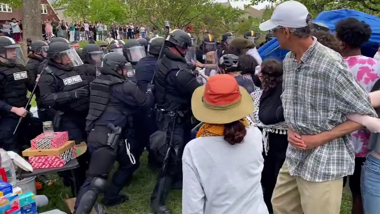 Indiana State Police wearing riot gear attempt to clear out an encampment at Indiana University Bloomington on April 27.
