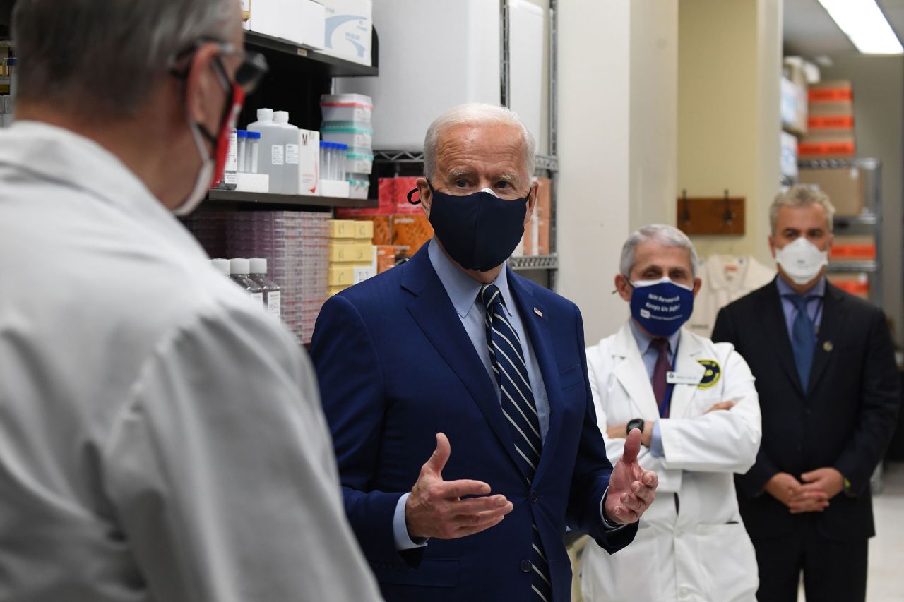 President Joe Biden speaks to Dr. Barney S. Graham, left), as Dr. Anthony Fauci listens during a tour of the Viral Pathogenesis Laboratory at the National Institutes of Health in Bethesda, Maryland, on February 11.