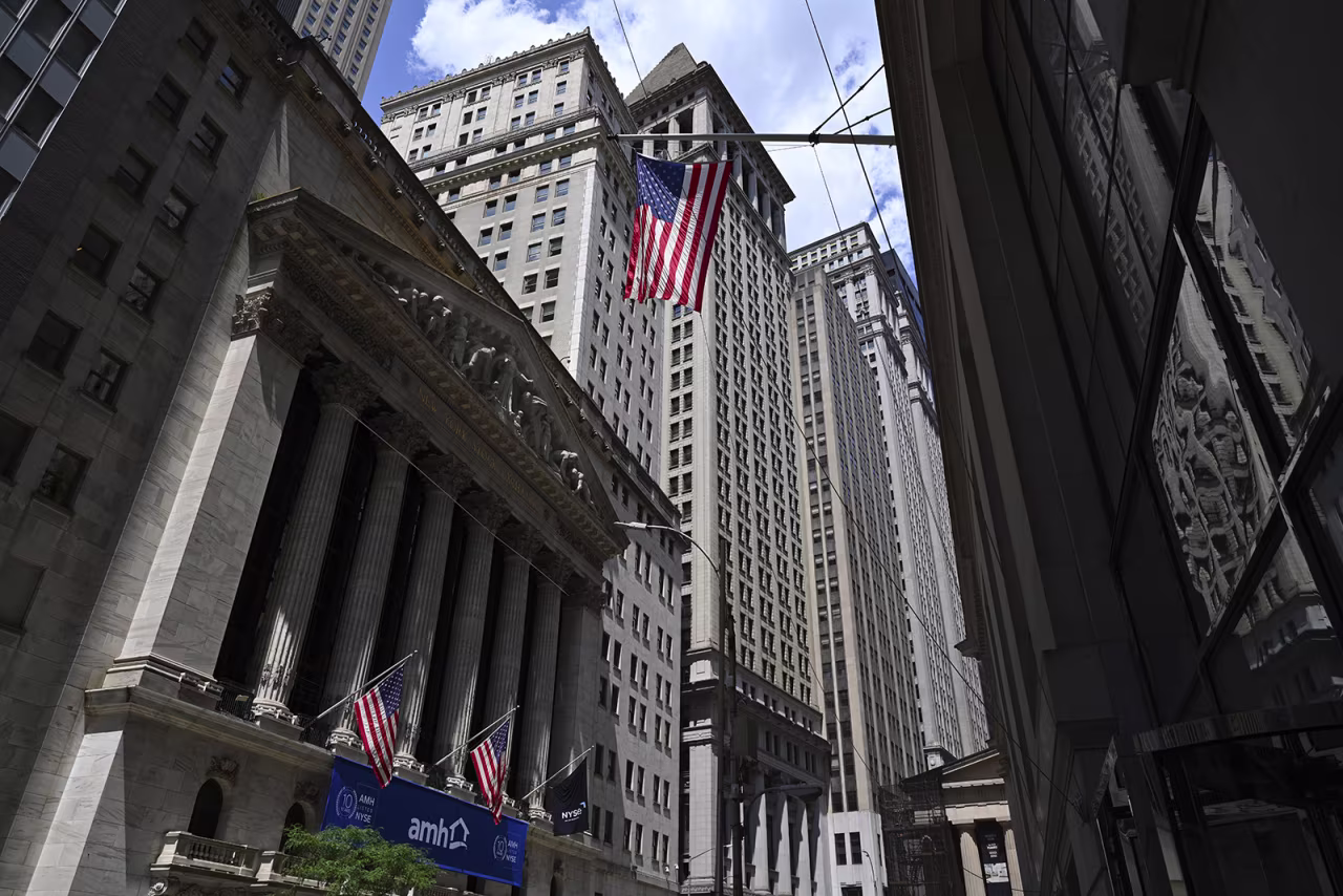 People walk past the New York Stock Exchange on Wall Street on August 1 in New York City.