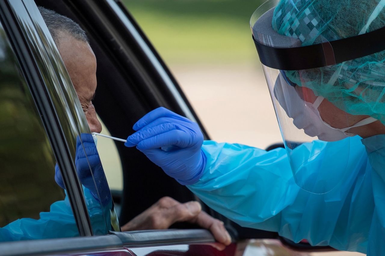 A healthcare worker uses a swab to test a man at a Covid-19 drive-in testing location in Houston, Texas. 