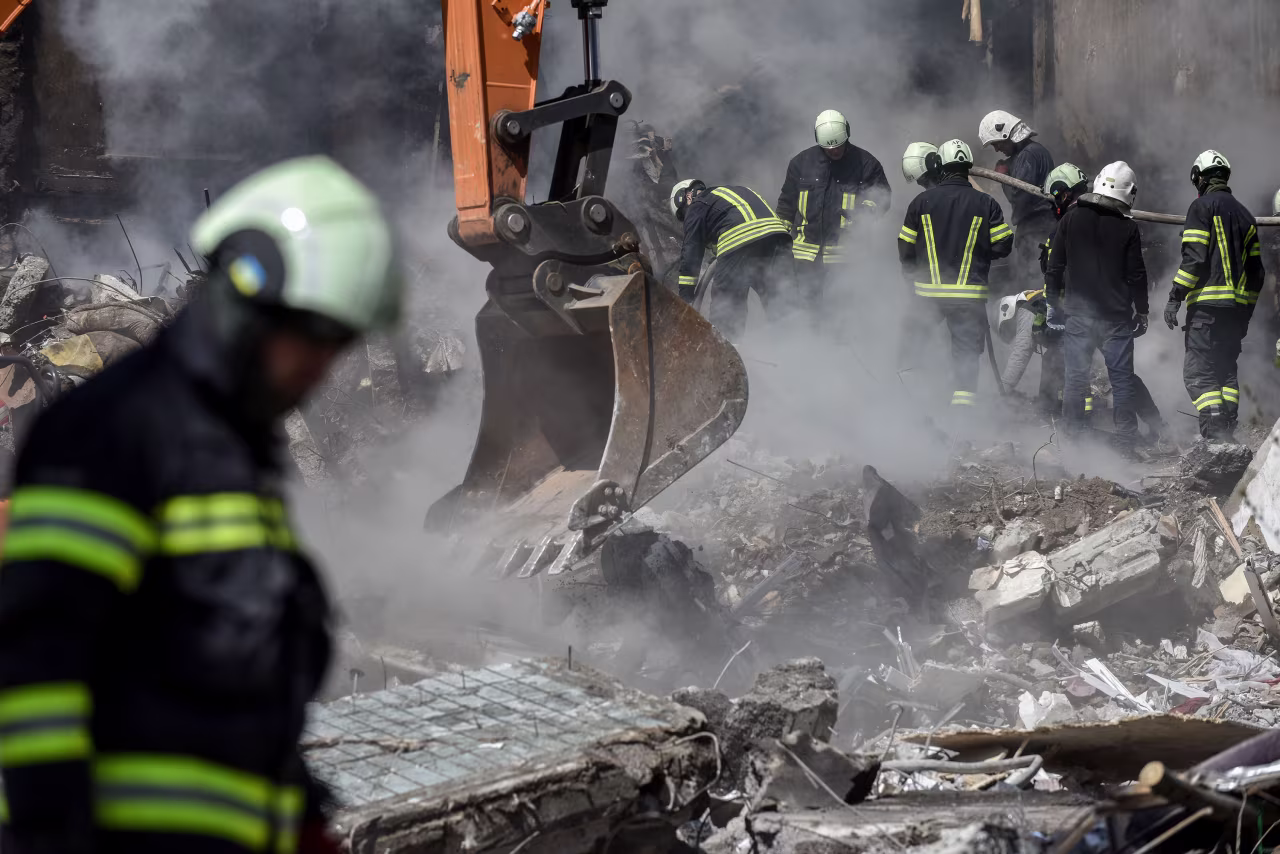 Rescuers work at the site of a damaged residential building in Uman, Ukraine, on Friday.
