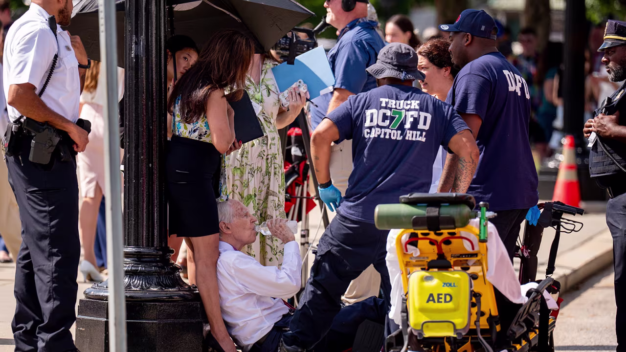 A man is attended to after fainting in the heat outside the Supreme Court in Washington, DC on June 20. 