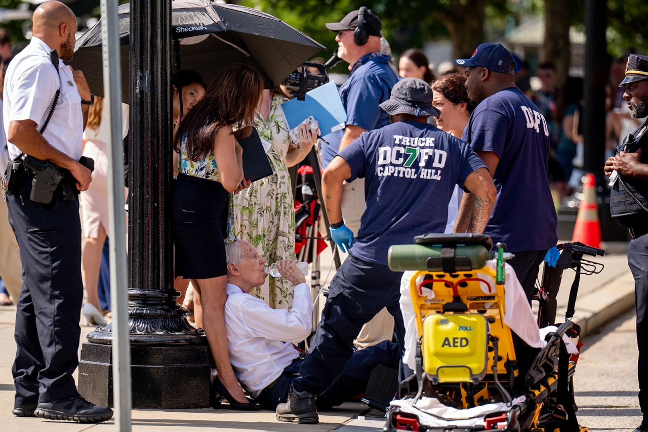 A man is attended to after fainting in the heat outside the Supreme Court in Washington, DC on June 20. 