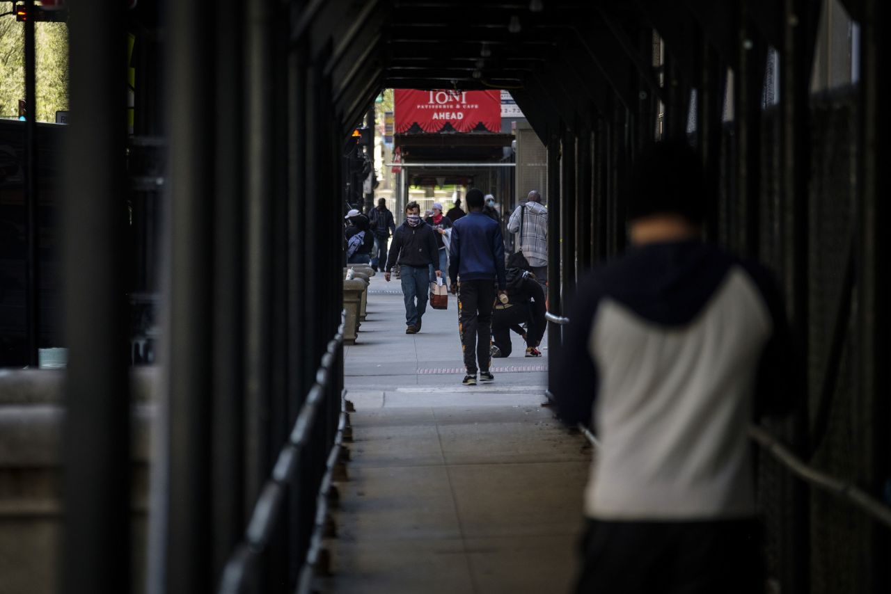 Pedestrians wearing protective masks walk down the street in Chicago, on May 7.