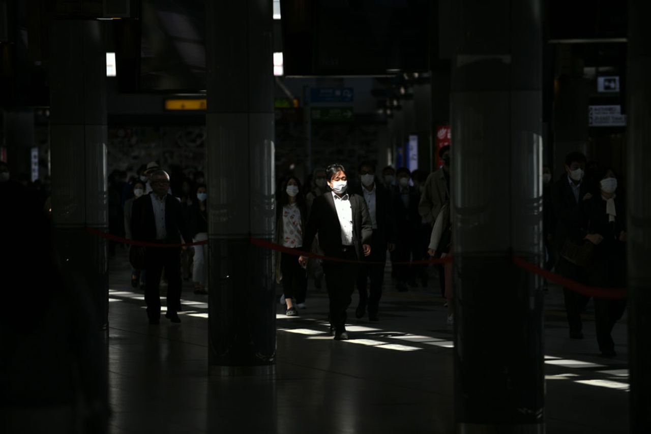 People wearing face masks walk during rush hour at Shinagawa railway station in Tokyo on May 7.