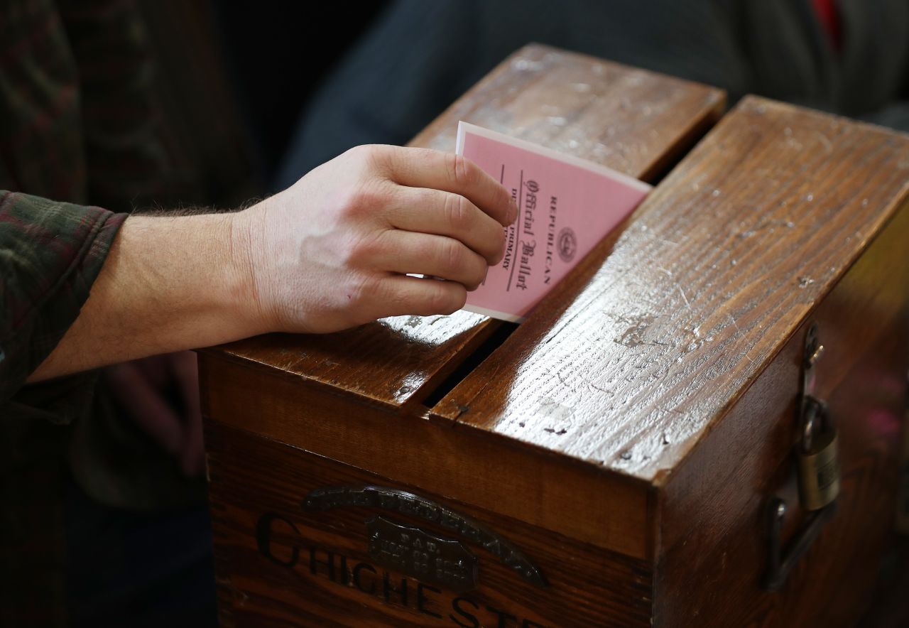 A voter drops a ballot into the ballot box in Chichester, New Hampshire, in February 2020. 