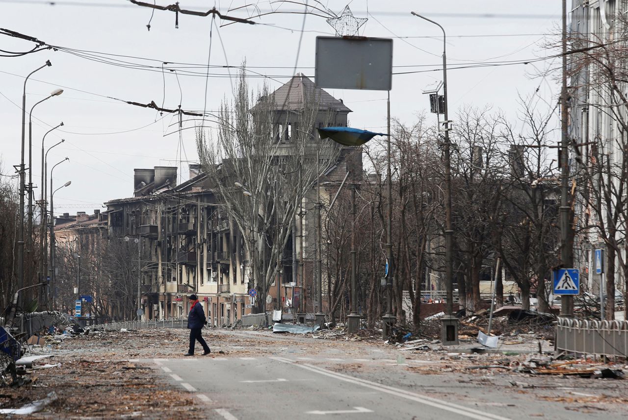 A local resident crosses a street damaged during Ukraine-Russia conflict in the southern port city of Mariupol, Ukraine on April 3.