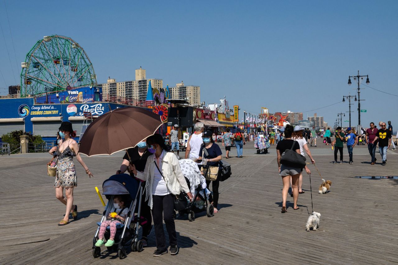 People walk on the Coney Island beach boardwalk in New York City on May 19.