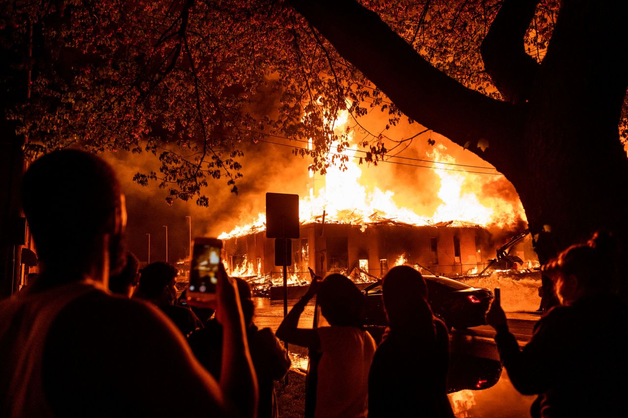 People look on as a construction site burns near the Third Police Precinct in Minneapolis, Minnesota, on May 27.