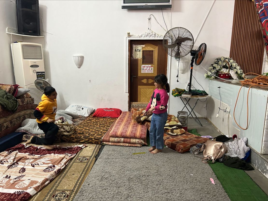 Fatima Tawfeeq's grandchildren Rou’ya and Mahmoud play in a wedding hall that has been converted into a makeshift shelter in the nearby town of Kafr al-Labad.