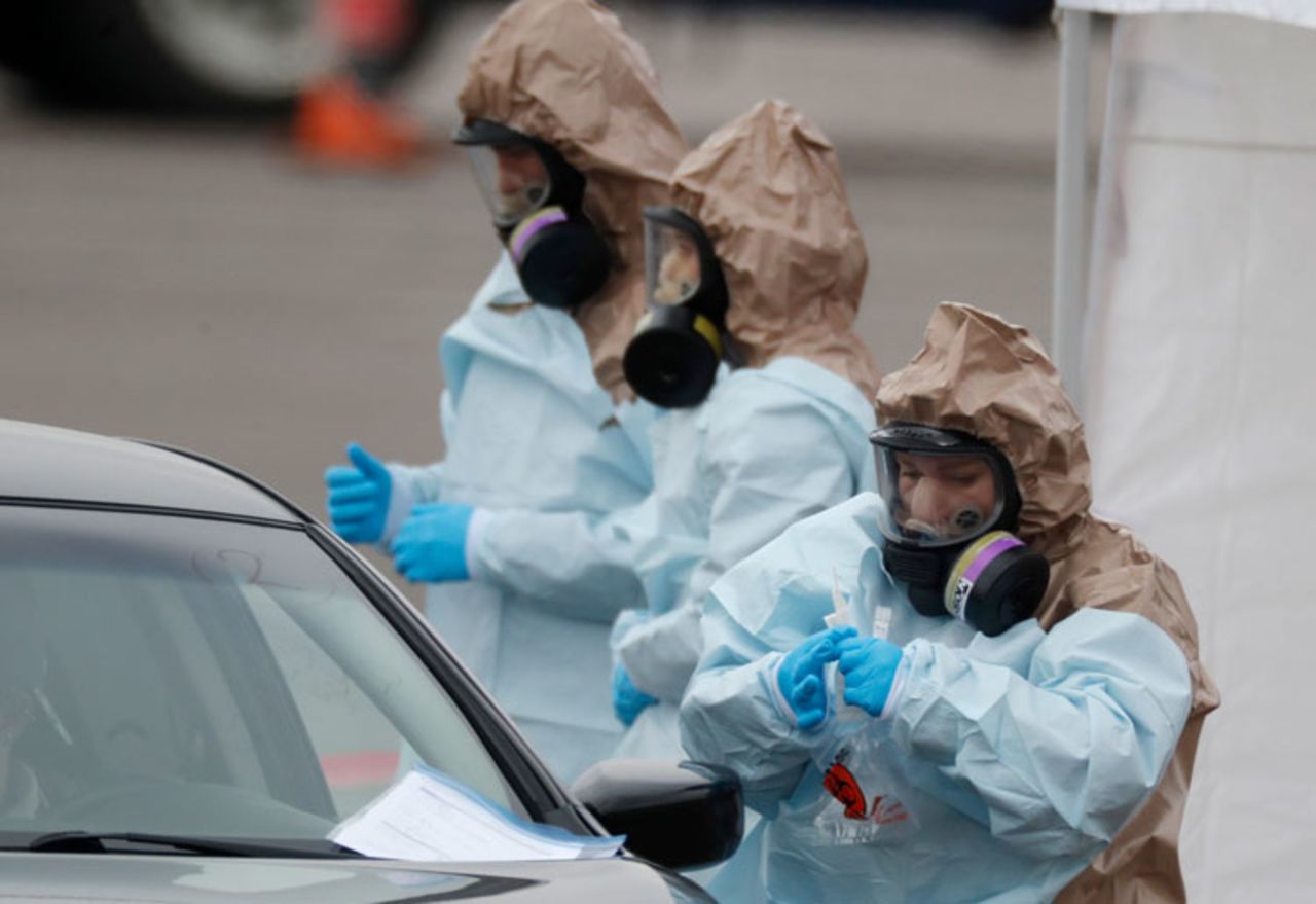 Colorado National Guard medical personnel perform a coronavirus test on a motorist at a drive-through testing site outside the Denver Coliseum Saturday, March 14, in Denver. 