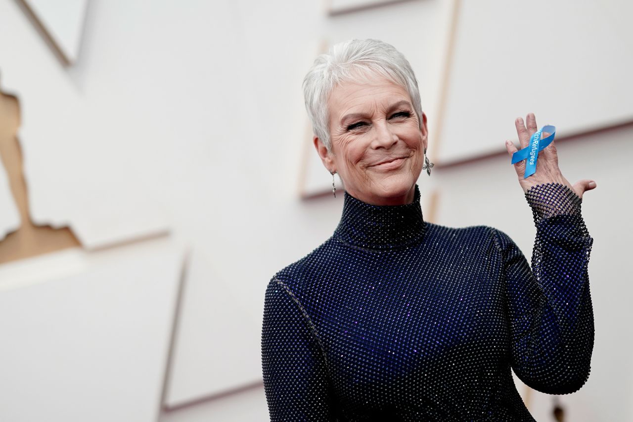 Jamie Lee Curtis holds up a blue ribbon in support of refugees of Ukraine as she arrives at the Oscars on Sunday, March 27.