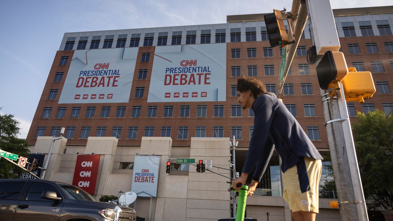 A man rides a scooter past CNN's Atlanta headquarters on Monday.