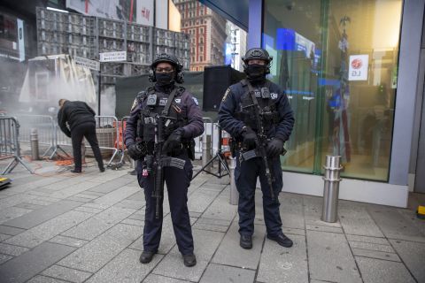 NYPD police officers with rifles stand in Times Square in New York City on Thursday, December 30, 2021. Officers from the Counterterrorism Bureau and other NYPD units will patrol during the New Year's Eve bash on Friday. Revelers must wear face masks and prove they have been vaccinated against COVID-19. 