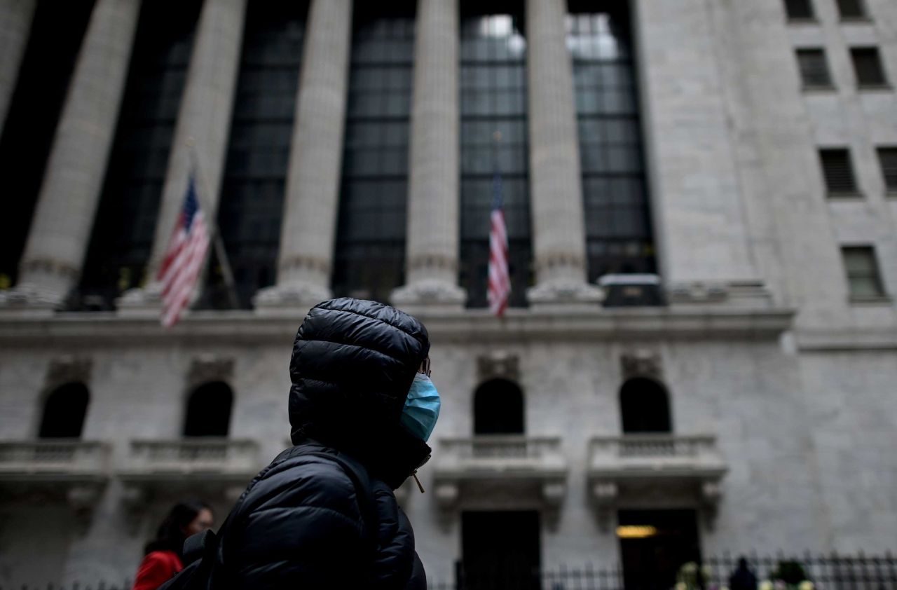 A person wearing a facial mask passes the New York Stock Exchange on February 3.