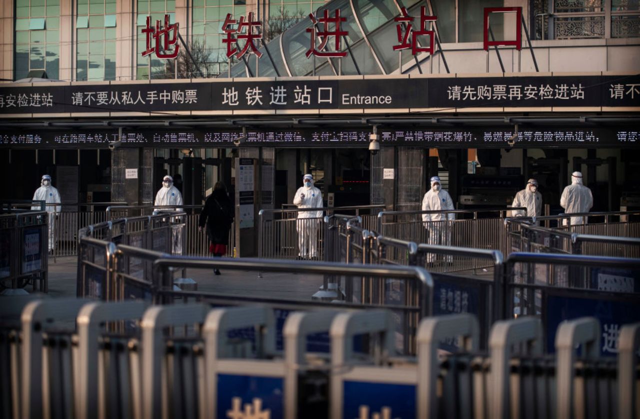 Chinese health workers wait to check the temperatures of travellers entering a subway station on January 25, 2020 in Beijing, China. 