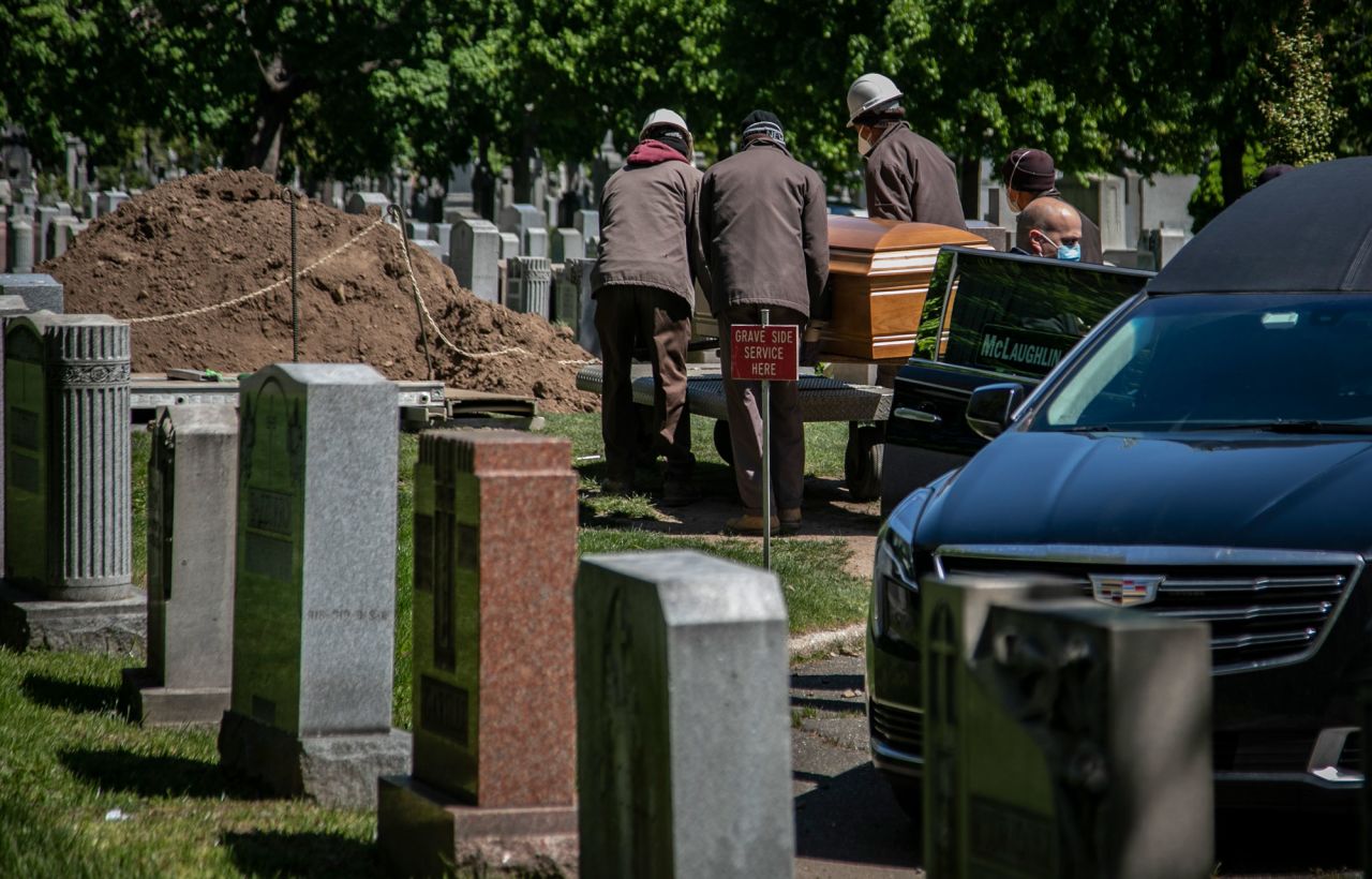 A casket is carried from a hearse to a burial site with no family present because of coronavirus restrictions on May 13 at Holy Cross Cemetery in the Brooklyn borough of New York. 