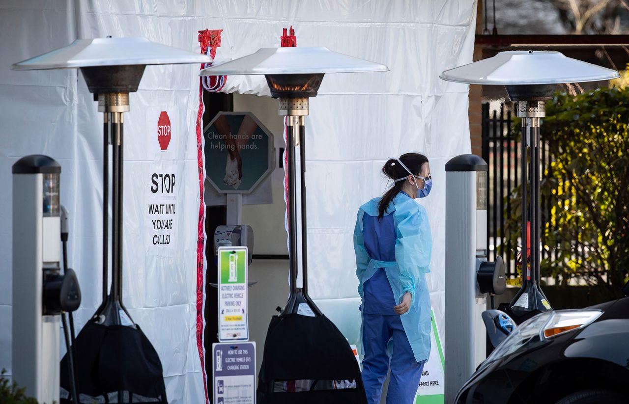 A hospital worker stands outside Lions Gate Hospital in British Columbia, on Thursday, March 19.