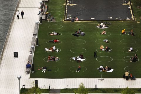 People sit in circles meant to encourage social distancing in Domino Park along the East River on May 18 in the Williamsburg neighborhood of the Brooklyn borough in New York City.