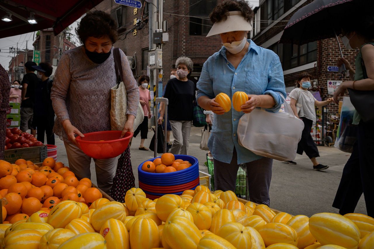 Shoppers walk through a market in Seoul on June 10.