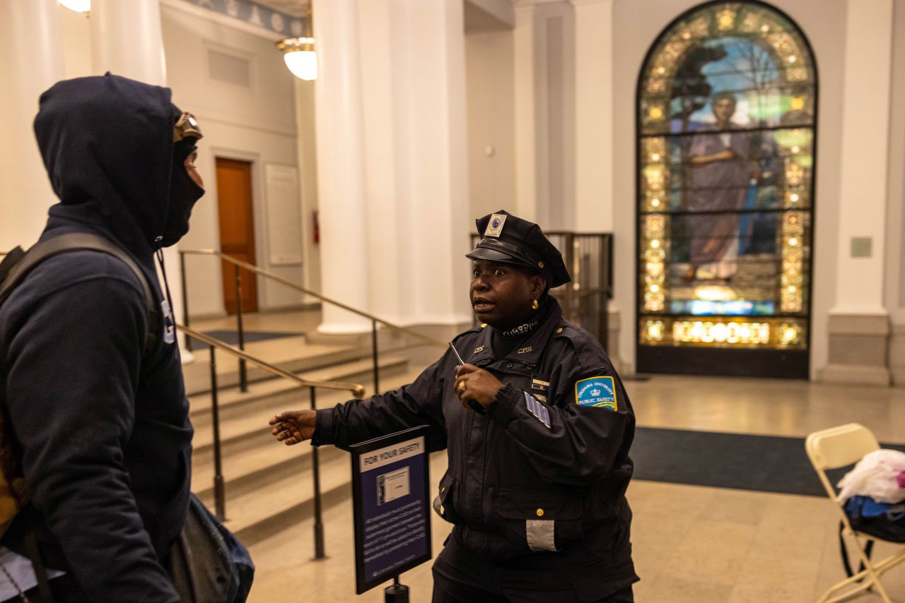 A Columbia University Public Safety officer confronts protesters inside Hamilton Hall.