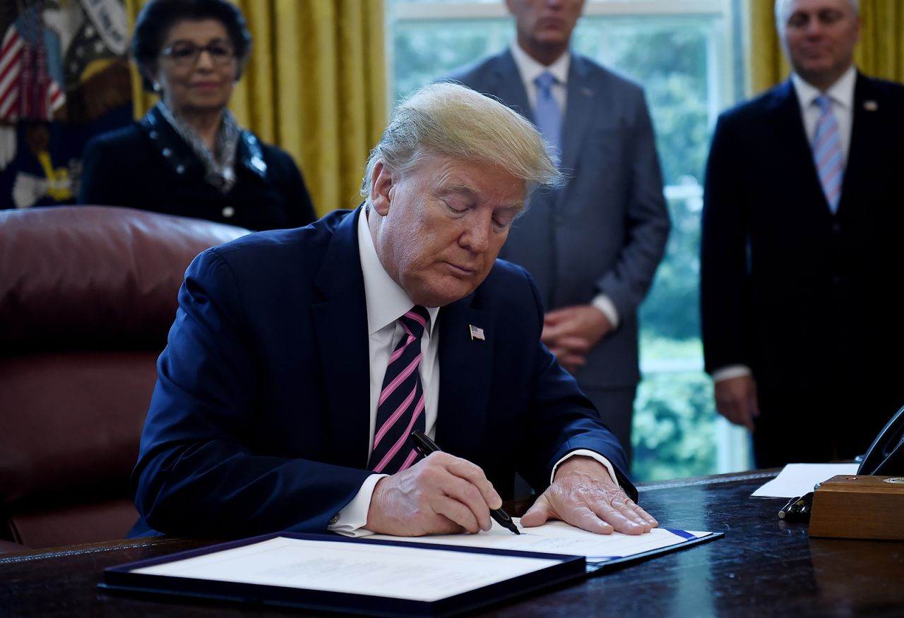 US President Donald Trump signs the Paycheck Protection Program and Health Care Enhancement Act in the Oval Office of the White House in Washington, DC, on April 24.