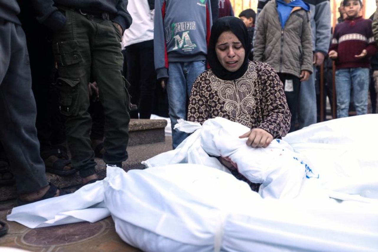 A mother hugs her 1-year-old son who was killed during Israeli air strikes in Khan Younis, Gaza, on Friday.