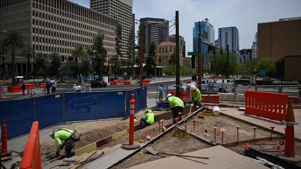 Construction workers shovel dirt while working during a heat advisory in downtown Phoenix, Arizona, on June 4.