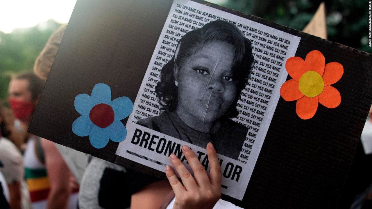 A demonstrator holds a sign with the image of Breonna Taylor, a Black woman who was fatally shot by Louisville Metro Police Department officers.