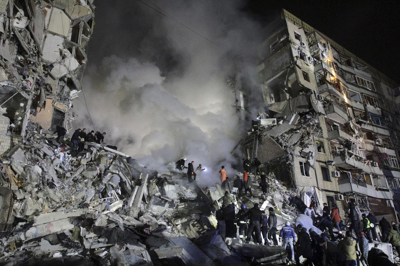 Rescuers remove rubble and search for people at an apartment block hit by a rocket launched by Russian forces during in Dnipro, Ukraine, on January 14.