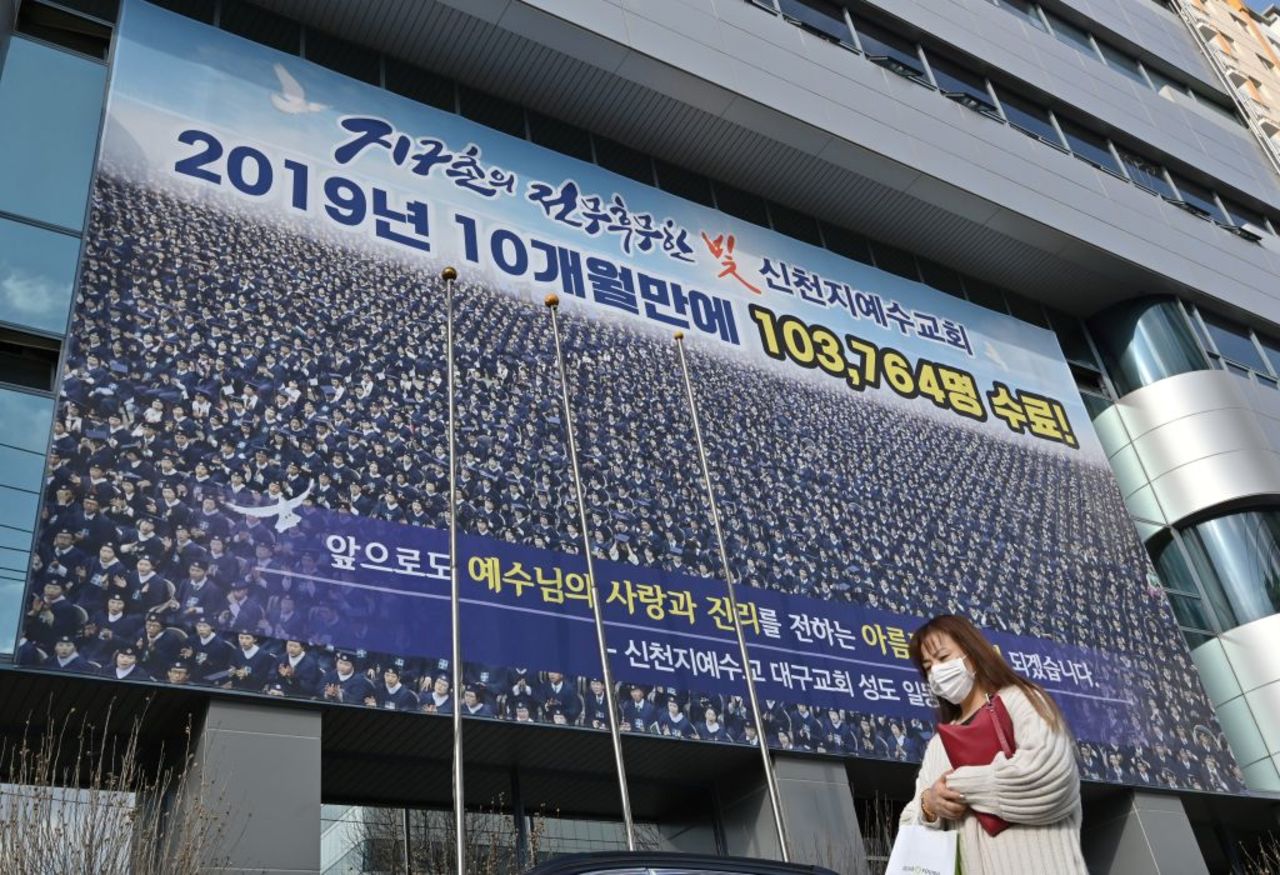 A woman wearing a face mask walks in front of the Daegu branch of the Shincheonji Church of Jesus in Daegu on February 27. 