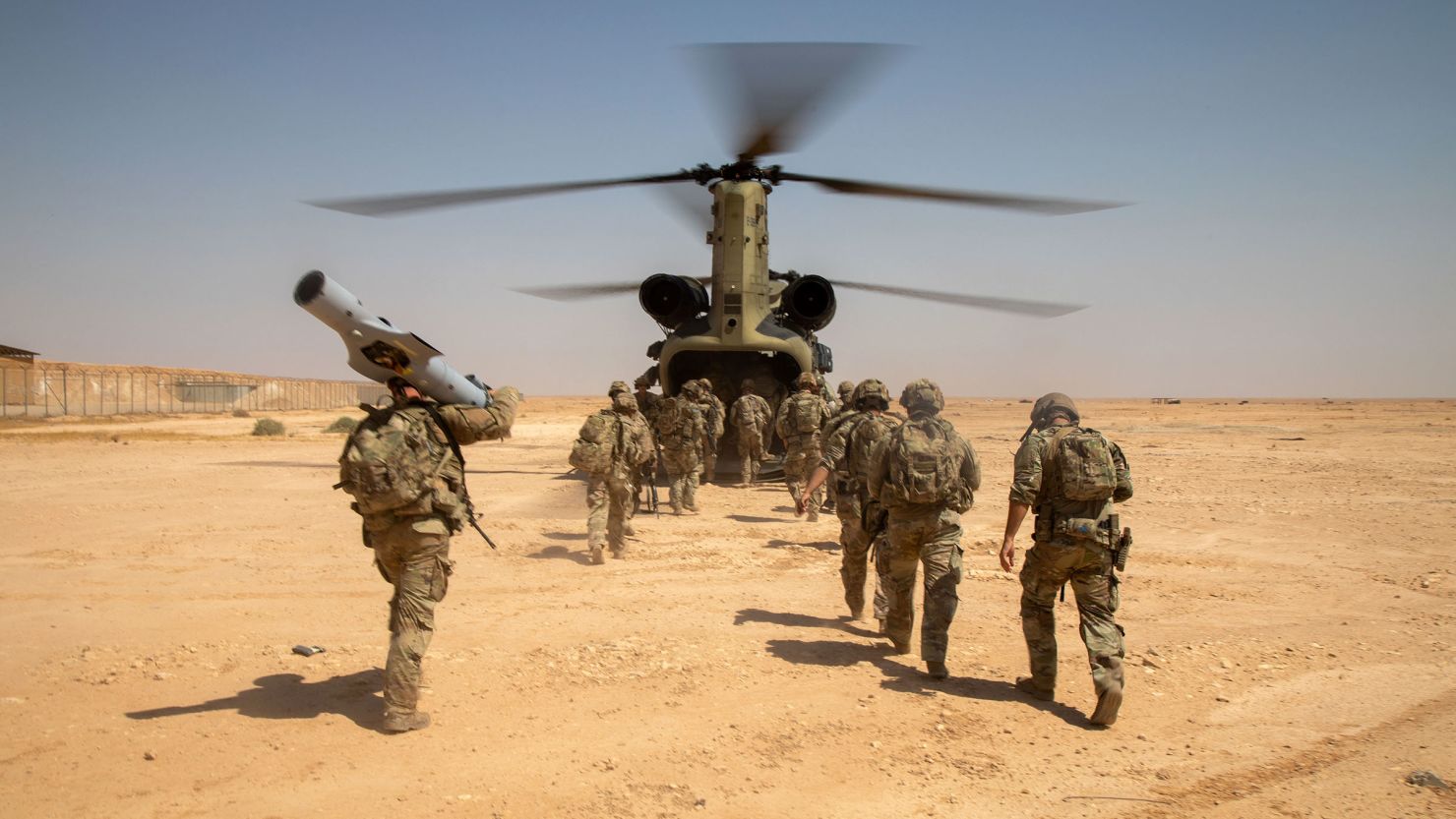 In this photo from the US Army, US Army Soldiers, assigned to 37th Infantry Brigade Combat Team, 125th Infantry Regiment, 1st Battalion, Combined Joint Task Force Operation Inherent Resolve, board a CH-47 Chinook helicopter after a live-fire exercise at Al Asad Air Base, Iraq, in July 2023.