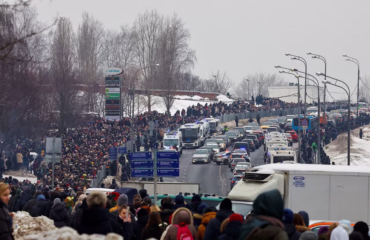 People walk towards the Borisovsky cemetery in Moscow after the funeral service.