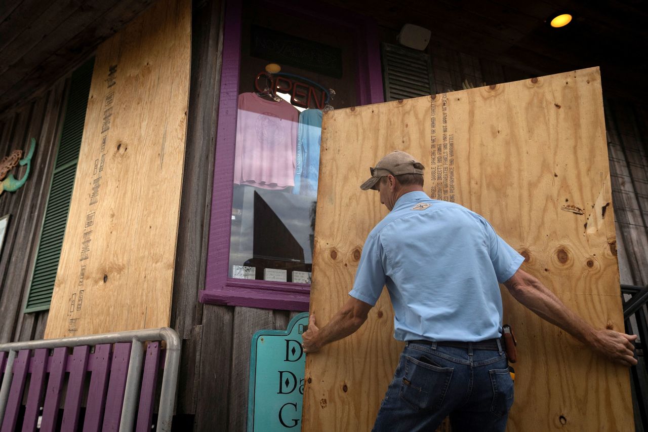 A man places plywood in front of a store in Cedar Key on Tuesday.