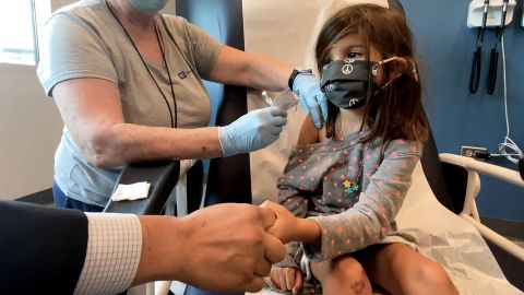 Bridgette Melo, 5, holds her father's hand while receiving a dose of the Pfizer/BioNTech Covid-19 vaccine during a trial at Duke University in Durham, North Carolina.
