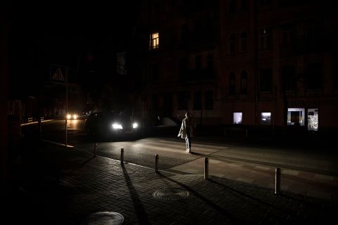 A woman walks near the Golden Gate in near total darkness in Kyiv on October 31.