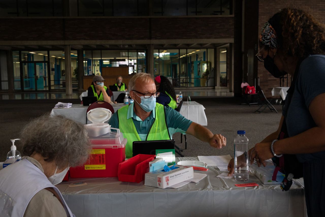 A patient shows her vaccination card to receive a booster dose of the Pfizer-BioNTech Covid-19 vaccine in Southfield, Michigan on August 24.