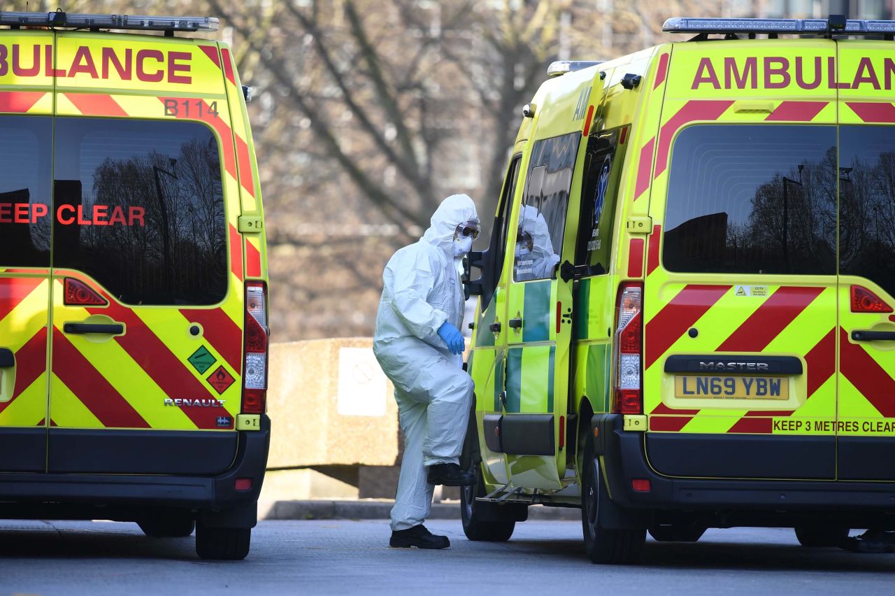 A member of the ambulance service leads a patient (not pictured) into an ambulance at St Thomas' Hospital in London on March 24.