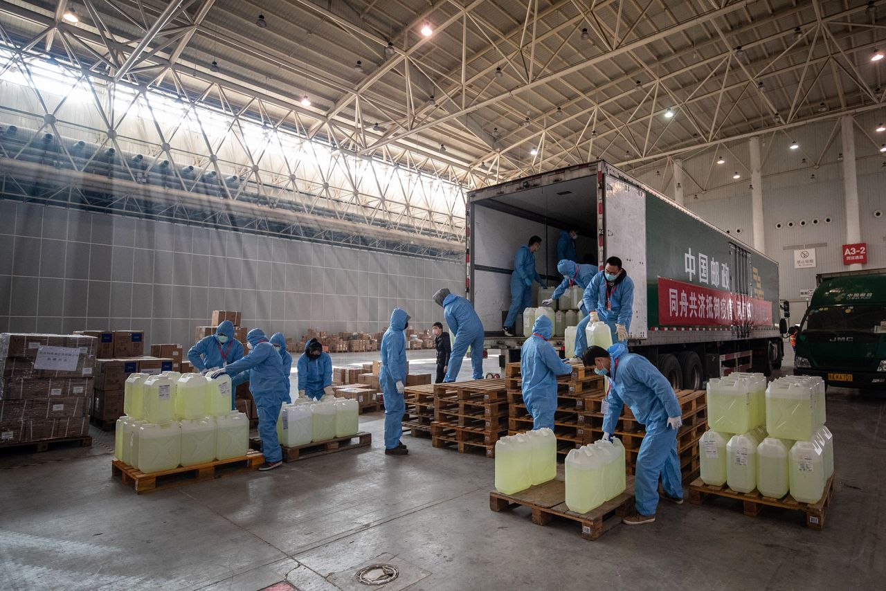 Staff members and volunteers transfer medical supplies from various sources at a warehouse of an exhibition center which has been converted into a makeshift hospital in Wuhan, on Tuesday.