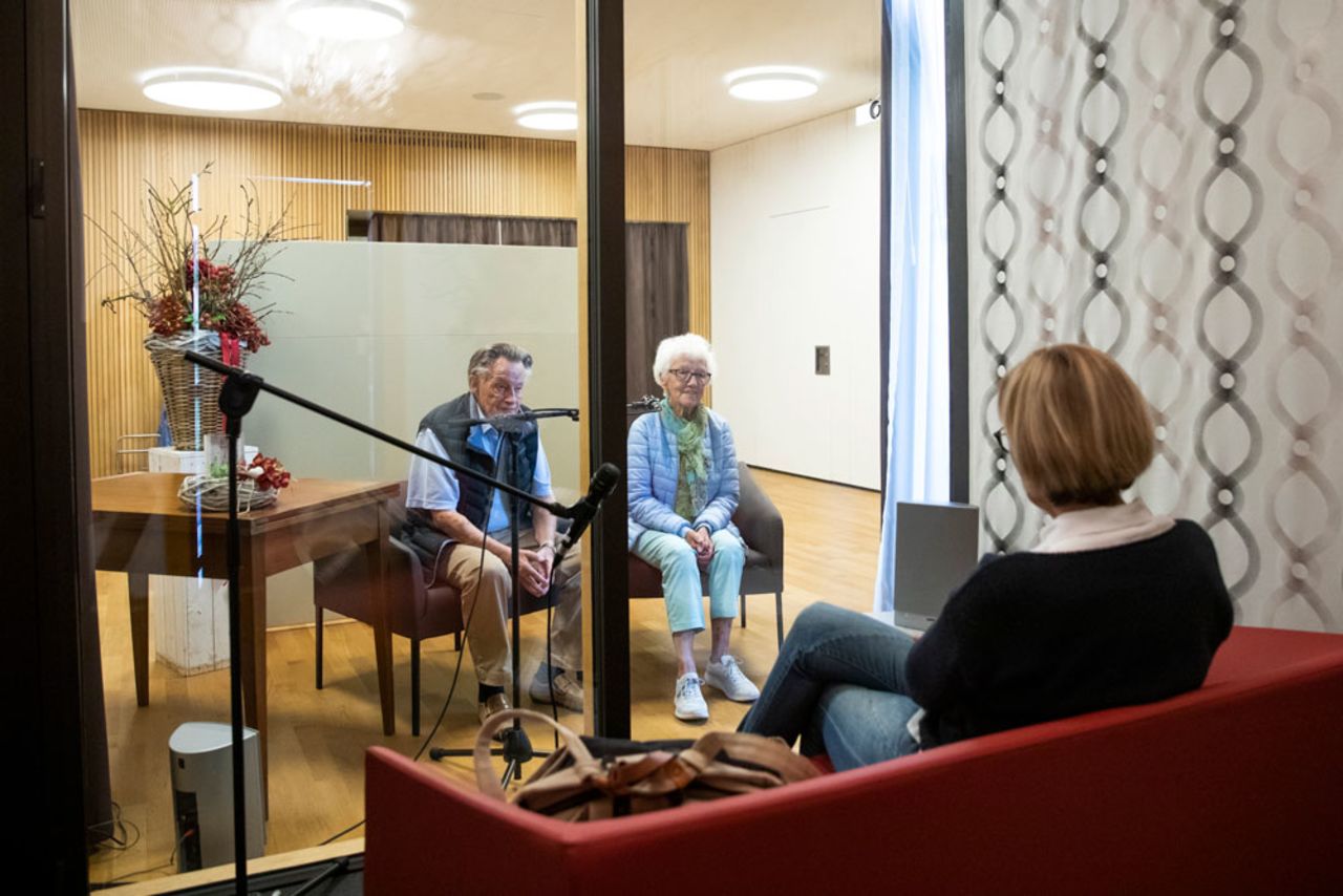 A daughter sits in the visitor's box and speaks with her parents, who are in the retirement home Burgerheim Thun, on Wednesday, April 29 in Steffisburg, Switzerland.