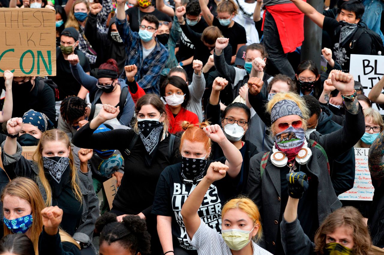 Protesters take a knee and raise their fists in a moment of silence for George Floyd and other victims of police brutality in Boston on June 7.