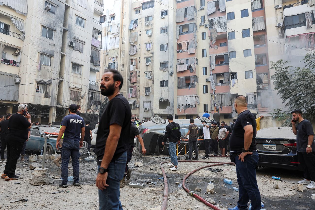 Lübnan'ın başkenti Beyrut'un güney banliyölerinde 20 Eylül'de gerçekleşen İsrail saldırısının yerini inceleyen halk.